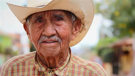 An Older Mexican Man In A Cowboy Hat At A Market Smiles ...