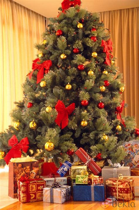 Árbol de Navidad con lazos y bolas rojas y doradas ...