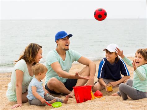 Família feliz brincando com bola na praia arenosa | Baixar ...