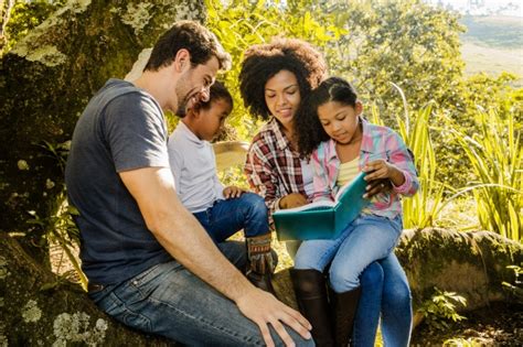 Família feliz lendo juntos sob uma árvore | Baixar fotos ...