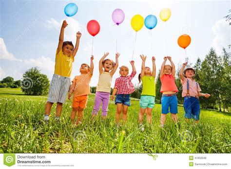 Happy Kids With Balloons And Arms Up In The Sky Stock ...