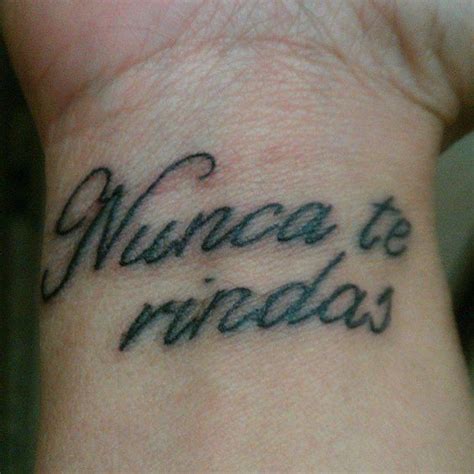 Little wrist tattoo saying “Nunca te rindas”, spanish ...