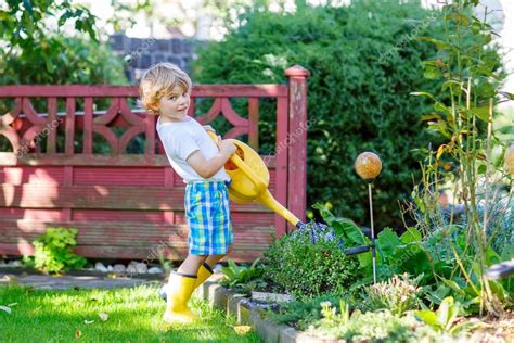 niño niño, regar las plantas en el jardín en verano — Foto ...
