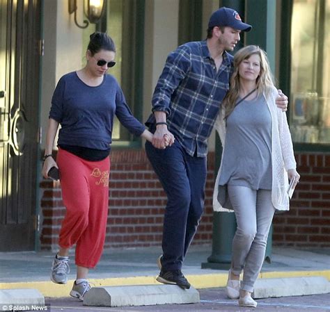 Pregnant Mila Kunis cradles her burgeoning baby bump as ...