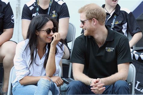 Prince Harry and Meghan Markle holding hands and sitting ...