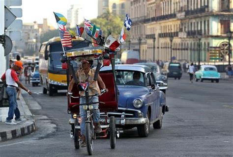 Un bicitaxi adornado con varias banderas, entre ellas una ...