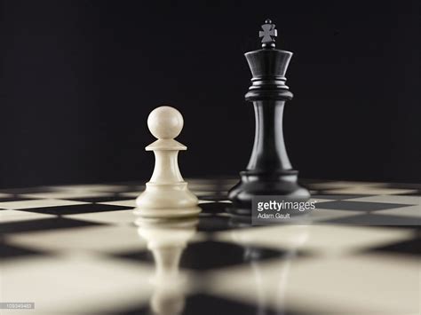 White Pawn Chess Piece Facing Black King On Chess Board ...